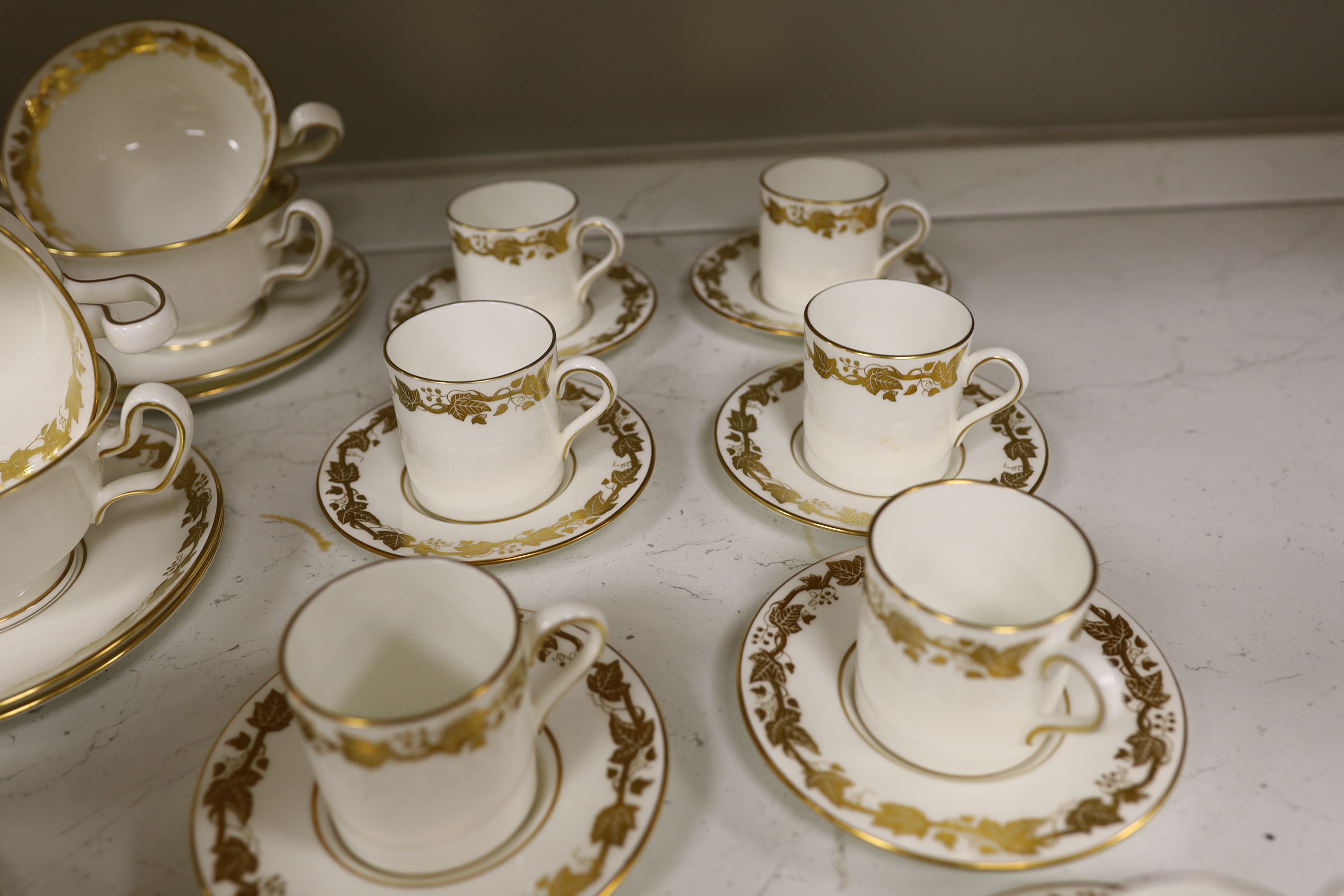 A Wedgwood gilt vine pattern dinner and coffee service for twelve